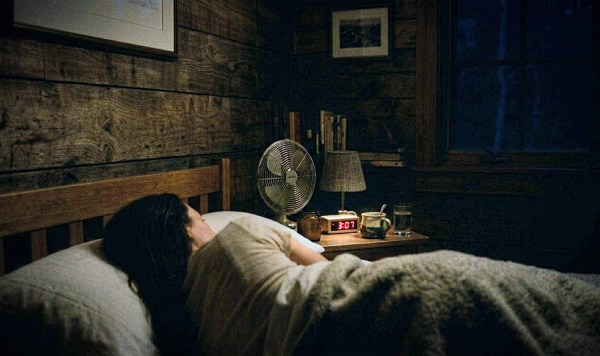 Woman lying awake in bed at 3am.